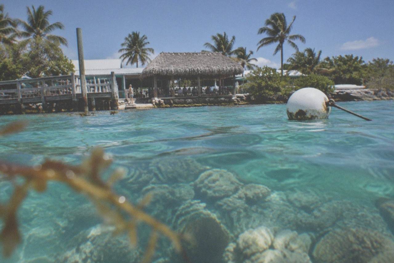Calm turquoise water over a Florida Keys reef with a marker buoy floating above the coral