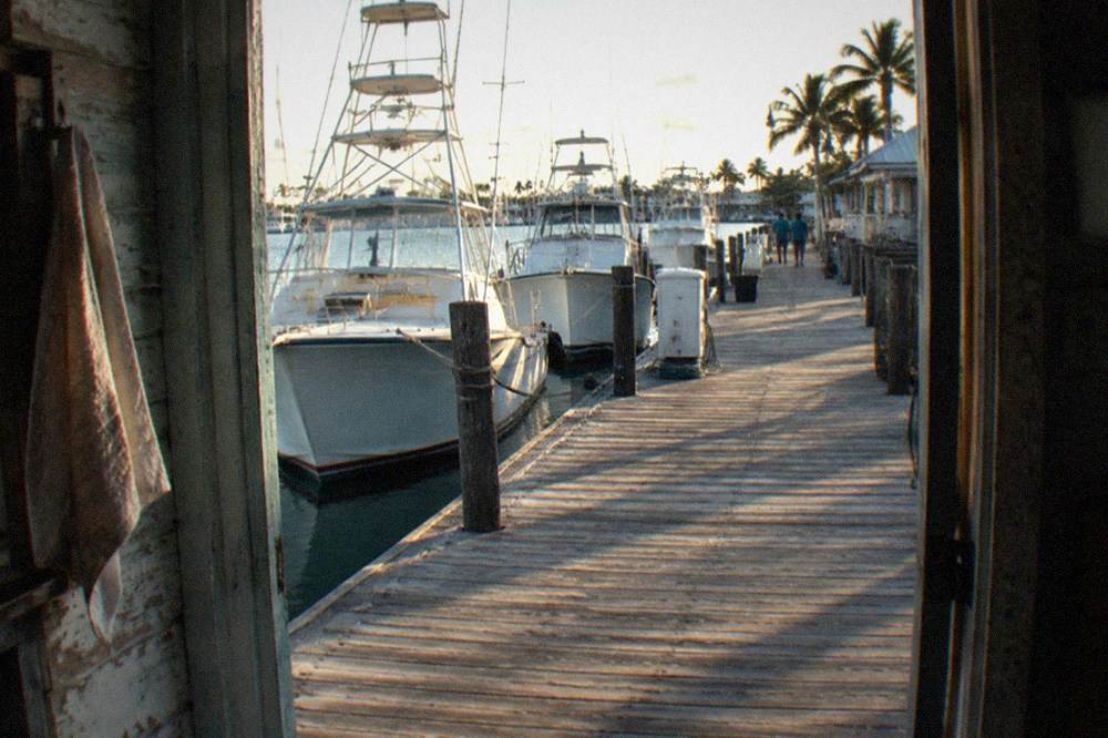 Old wooden dock with fishing boats moored along the Key West waterfront