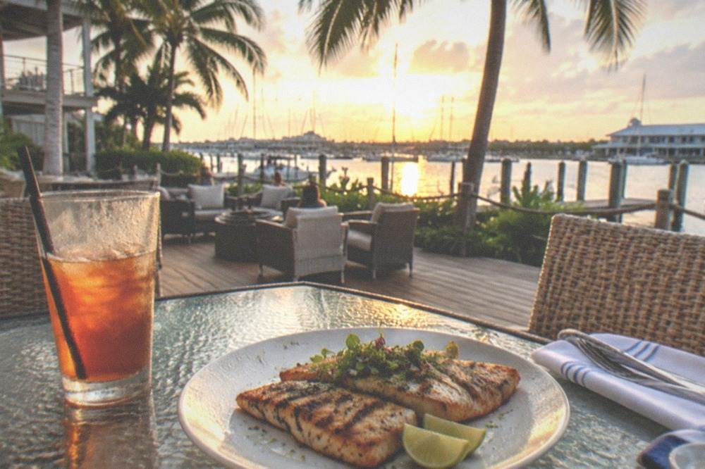 Grilled mahi fillets plated with lime wedges beside a waterfront table