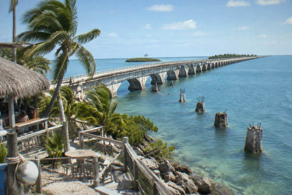 The Seven Mile Bridge stretching over calm blue water with small islands on the horizon