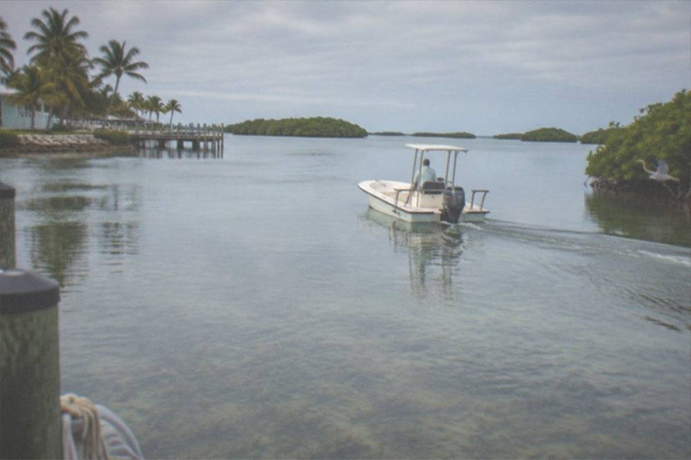 Small private bay boat cruising across calm backcountry flats water near Key West