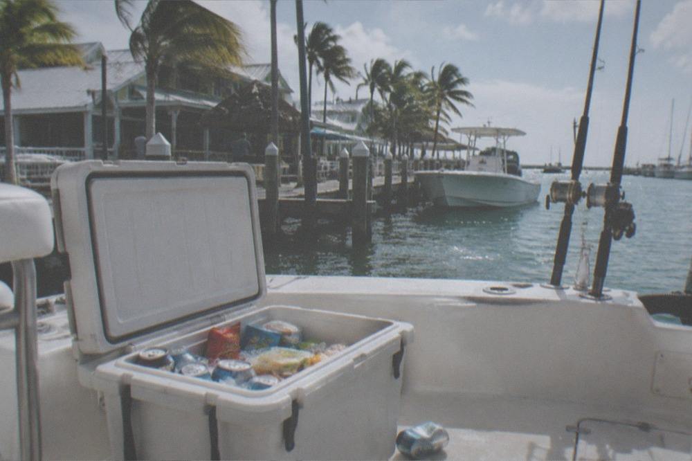 Cooler with drinks and snacks open on the deck of a fishing boat at a Key West dock