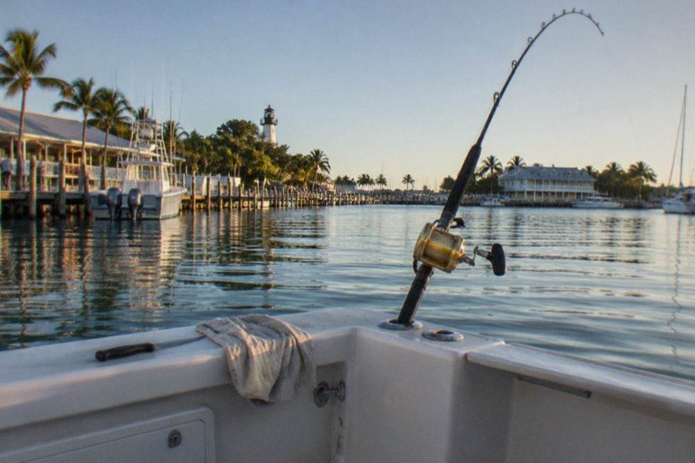 A fishing rod bent in a rod holder at the back of an offshore charter boat