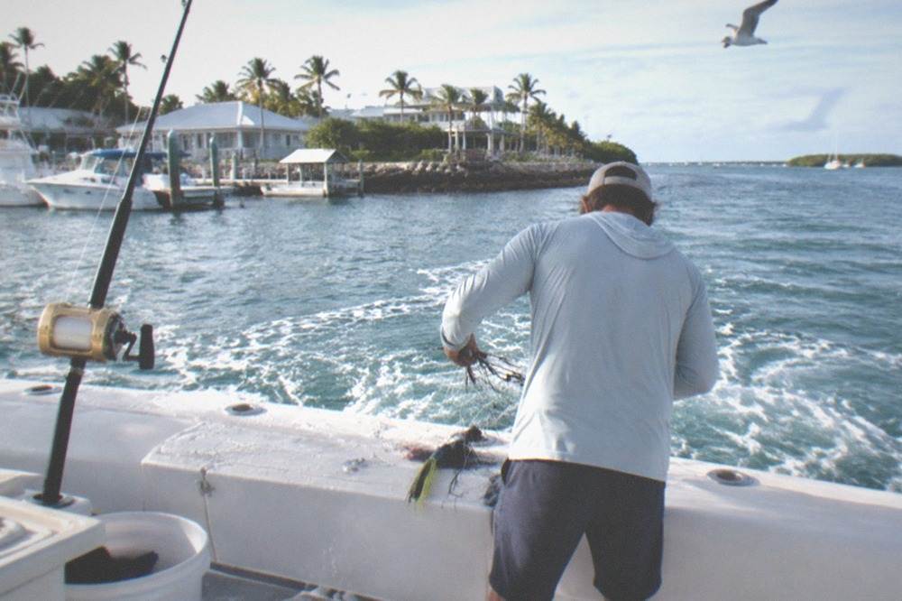 A mate clearing lines on the deck of a charter boat at sea