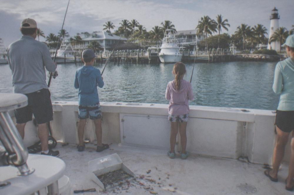 Family group holding rods on the deck of a charter boat near Key West