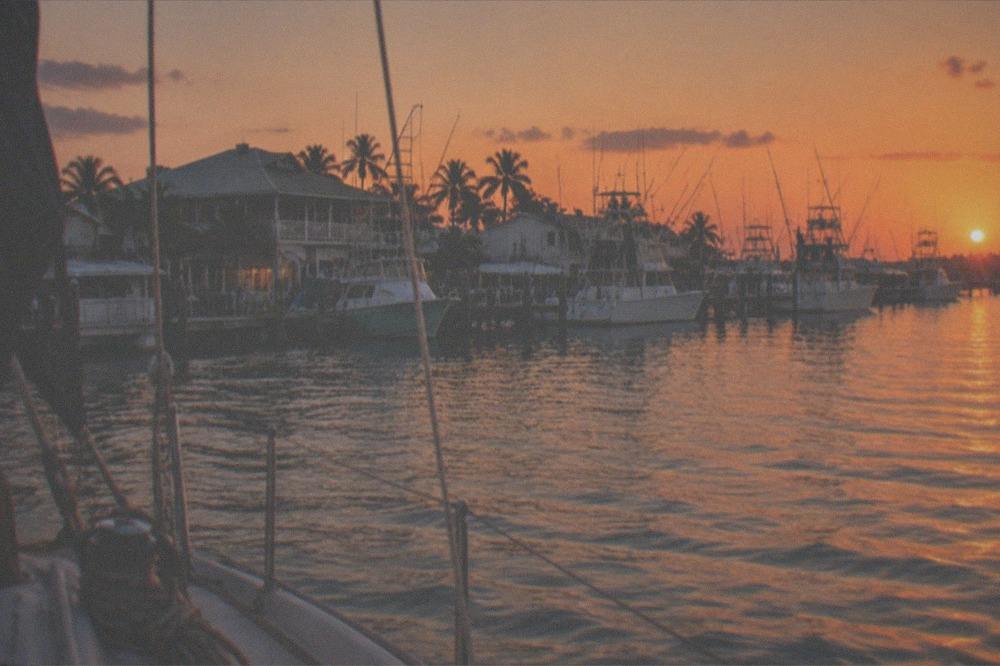 Sunset over a Key West marina with fishing boats moored along the docks