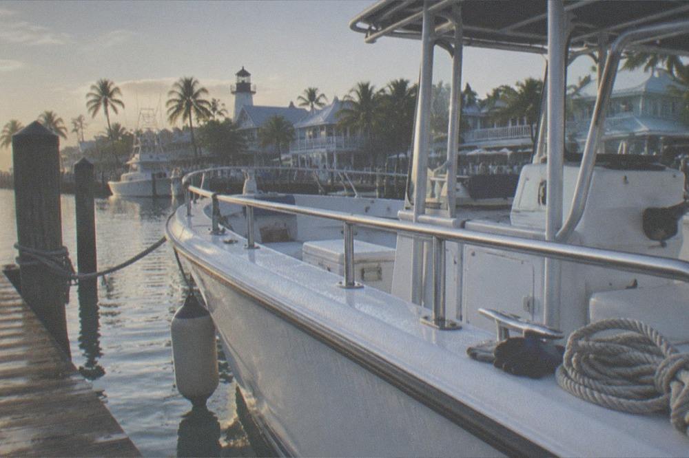 A private charter boat tied at a Key West marina dock in early morning light