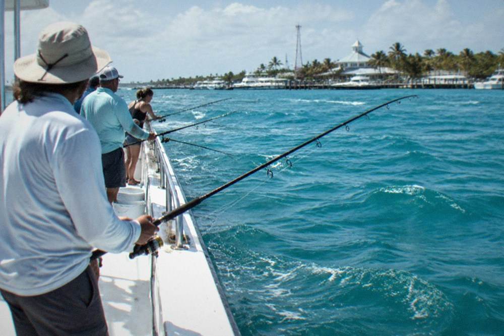 Anglers fishing along the rail of a large party boat catamaran on open water near Key West