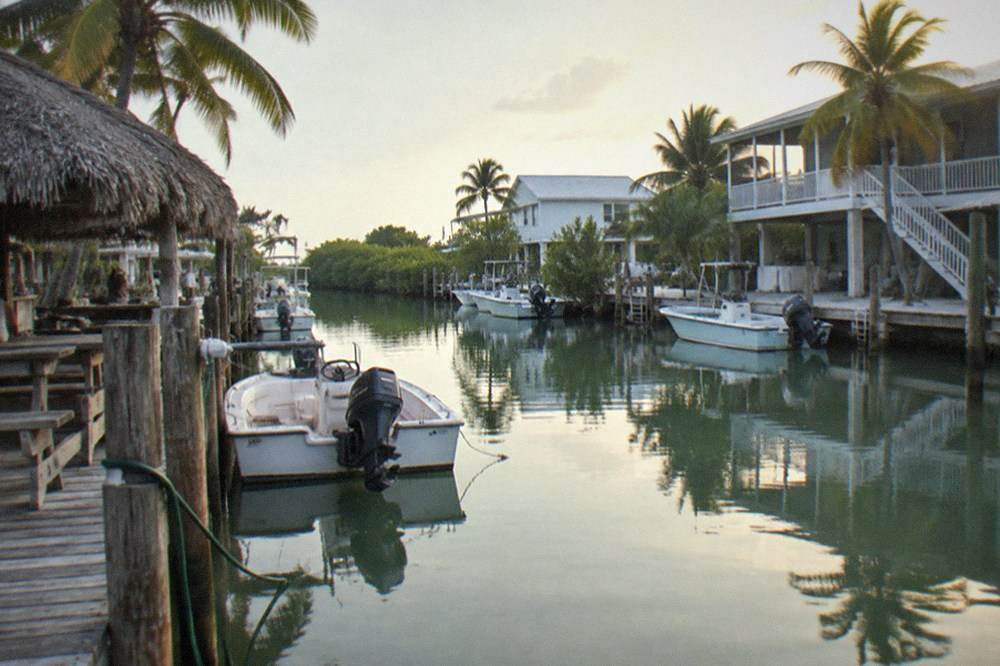 A quiet Lower Keys canal with small boats tied to residential docks